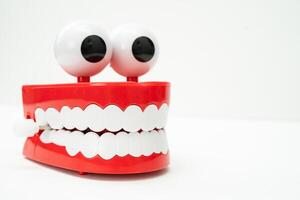 Tooth funny toy denture red color jaw and eye on white background with copy space. photo
