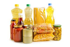 Foodstuff for donation isolated on white background with clipping path, storage and delivery. Various food, pasta, cooking oil and canned food in cardboard box. photo