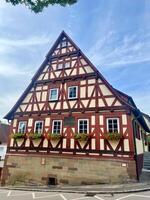 Germany - 09.17.2024 Traditional half-timbered house with flowers on the windows in a German village against the blue sky photo