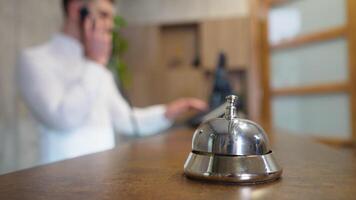 Front desk bell for call staff service. Receptionists working at desk in modern lobby video