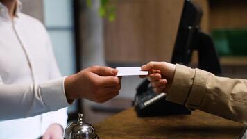 Guest gives card keys to the receptionist in hotel lobby. Check out from hotel video