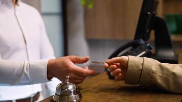 Guest gives keys to the receptionist in hotel lobby. Check out from hotel video