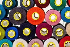 set of multi-colored spools of thread for sewing photo