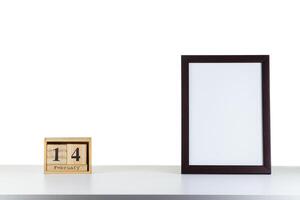 Wooden calendar 14 february with frame for photo on white table and background