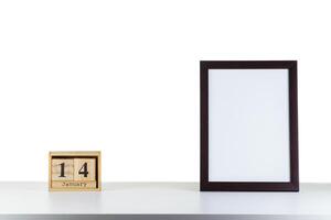 Wooden calendar 14 January with frame for photo on white table and background