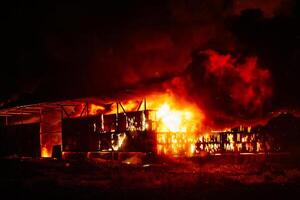 Exploding warehouse. Burning industrial building. Big blaze at night photo