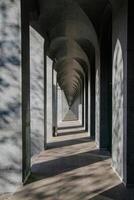 Long abstract unlimited corridor with rows of columns in sunlight photo