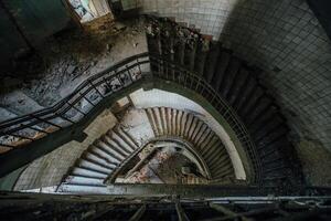 Old spiral staircase at the old abandoned building, top view photo