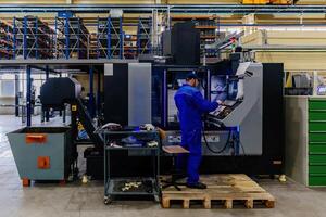 Operator works with modern CNC milling and cutting machinery photo