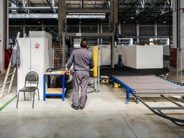 Workers at foam rubber blocks cutting machine photo
