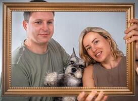 Portrait of a young family with a dog on the frame photo