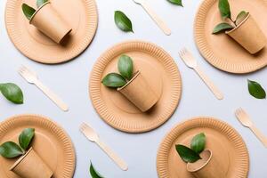 set of empty reusable disposable eco-friendly plates, cups, utensils on light white colored table background. top view. Biodegradable craft dishes. Recycling concept. Close-up photo