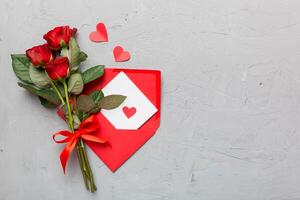 Valentine day composition with Envelope, rose flower and Red heart on table. Top view, flat lay. Holiday concept photo