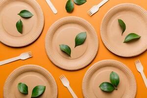 set of empty reusable disposable eco-friendly plates, cups, utensils on light white colored table background. top view. Biodegradable craft dishes. Recycling concept. Close-up photo