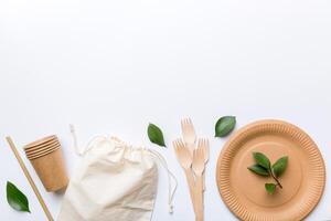 set of empty reusable disposable eco-friendly plates, cups, utensils on light white colored table background. top view. Biodegradable craft dishes. Recycling concept. Close-up photo