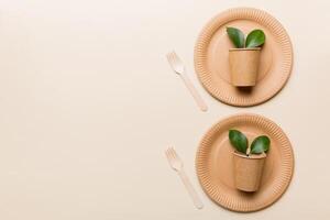set of empty reusable disposable eco-friendly plates, cups, utensils on light white colored table background. top view. Biodegradable craft dishes. Recycling concept. Close-up photo