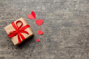 Valentine day composition red gift box with bow and heart. Christmas present. View from above. Space for text. Holday greeting card photo