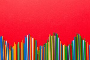Heap of colorful plastic drinking straws on Colored background, flat lay. Copy Space for text photo