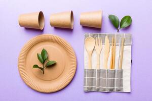 set of empty reusable disposable eco-friendly plates, cups, utensils on light white colored table background. top view. Biodegradable craft dishes. Recycling concept. Close-up photo