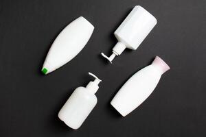 Set of White Cosmetic containers isolated on colored background, top view with copy space. Group of plastic bodycare bottle containers with empty space for you design photo