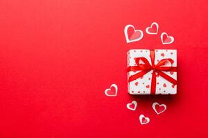 Valentine day composition red gift box with bow and heart. Christmas present. View from above. Space for text. Holday greeting card photo