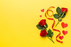 Valentine day composition with rose flower and red heart on table. Top view, flat lay, copy space Holiday concept photo