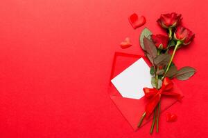 Valentine day composition with Envelope, rose flower and Red heart on table. Top view, flat lay. Holiday concept photo