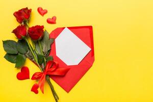 Valentine day composition with Envelope, rose flower and Red heart on table. Top view, flat lay. Holiday concept photo