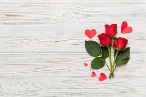 Valentine day composition with rose flower and red heart on table. Top view, flat lay, copy space Holiday concept photo