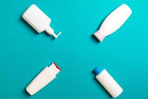 Set of White Cosmetic containers isolated on colored background, top view with copy space. Group of plastic bodycare bottle containers with empty space for you design photo