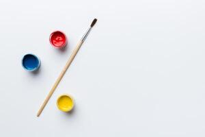 art palette with paint and brushes, close up. Top view with empty space. workplace for creativity. home teaching concept drawing photo