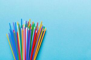 Heap of colorful plastic drinking straws on Colored background, flat lay. Copy Space for text photo