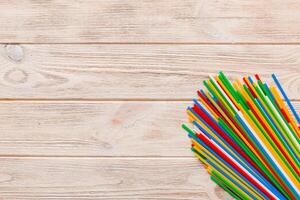 Heap of colorful plastic drinking straws on Colored background, flat lay. Copy Space for text photo