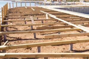 Timber foundation construction for a new house near the sea photo