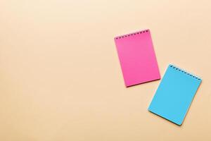 two school colored notebook on a desk background, spiral craft notepad on a table Top view photo