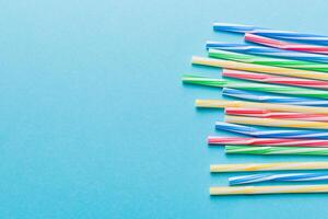 Heap of colorful plastic drinking straws on Colored background, flat lay. Copy Space for text photo