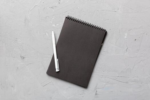 school notebook on a colored background, spiral black notepad on a table Top view photo