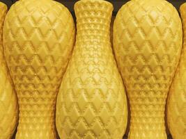 A collection of yellow decorative vases with diamond-textured patterns arranged in a row, creating a symmetrical and vibrant display photo