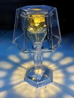 A beautiful glass lamp with intricate design casts stunning light patterns on the surface, perfect for concepts of elegance, ambiance, and interior decor photo