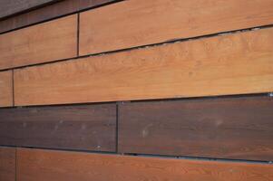 Brown rectangular decorative wooden planks, mirror panels in an abstract pattern. Element of finishing of the building facade. photo