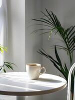 Photography with a white table, a cup of coffee, phone and greenery creating a tranquil atmosphere photo