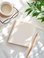 Photography with a serene workspace with a blank notebook, a cup of coffee, and greenery creating a tranquil atmosphere photo