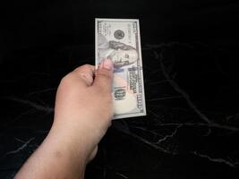 A person holding a dollar bill in their hand photo