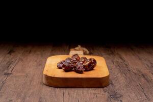 Many Date Palms are on bowls and cups of water and the Quran is on wooden tables, to wait for the time of Iftar, with the concept of ramadan Muslims around the world. photo