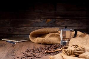 The picture of coffee beans stacked together on a wooden floor in a warm, light atmosphere, on a dark background, with copy space. photo