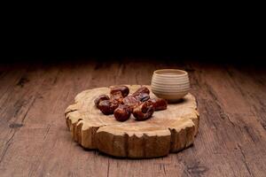 Many Date Palms are on bowls and cups of water and the Quran is on wooden tables, to wait for the time of Iftar, with the concept of ramadan Muslims around the world. photo