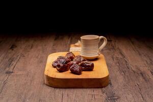 Many Date Palms are on bowls and cups of water and the Quran is on wooden tables, to wait for the time of Iftar, with the concept of ramadan Muslims around the world. photo