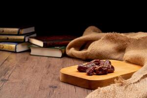 Many Date Palms are on bowls and cups of water and the Quran is on wooden tables, to wait for the time of Iftar, with the concept of ramadan Muslims around the world. photo