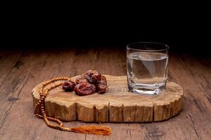 Many Date Palms are on bowls and cups of water and the Quran is on wooden tables, to wait for the time of Iftar, with the concept of ramadan Muslims around the world. photo
