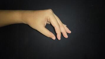 Hand by showing a gesture of taking an item or something small. Isolated on black background photo